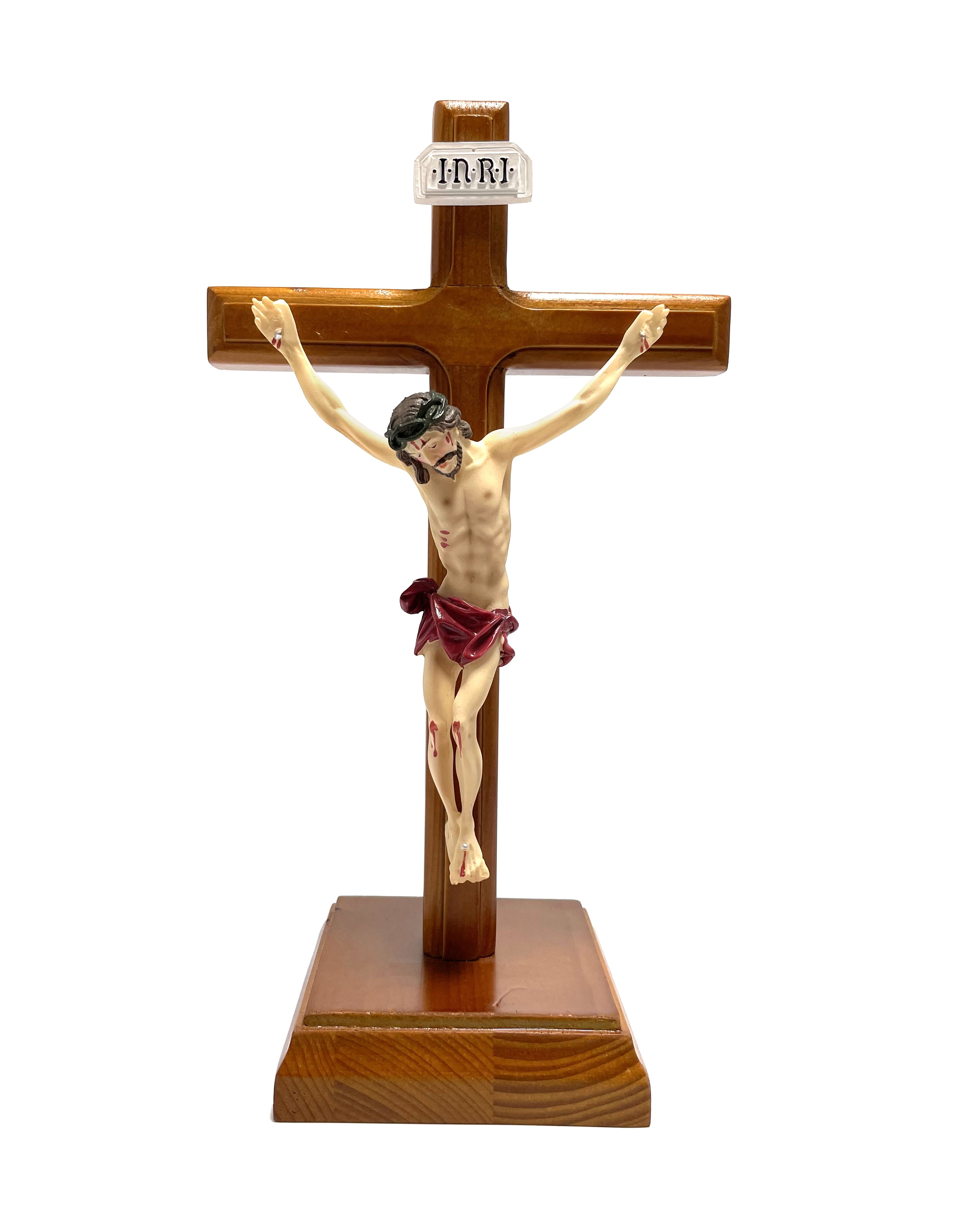 Crucifijo de madera con base cuadrada y cuerpo realizado en resina.