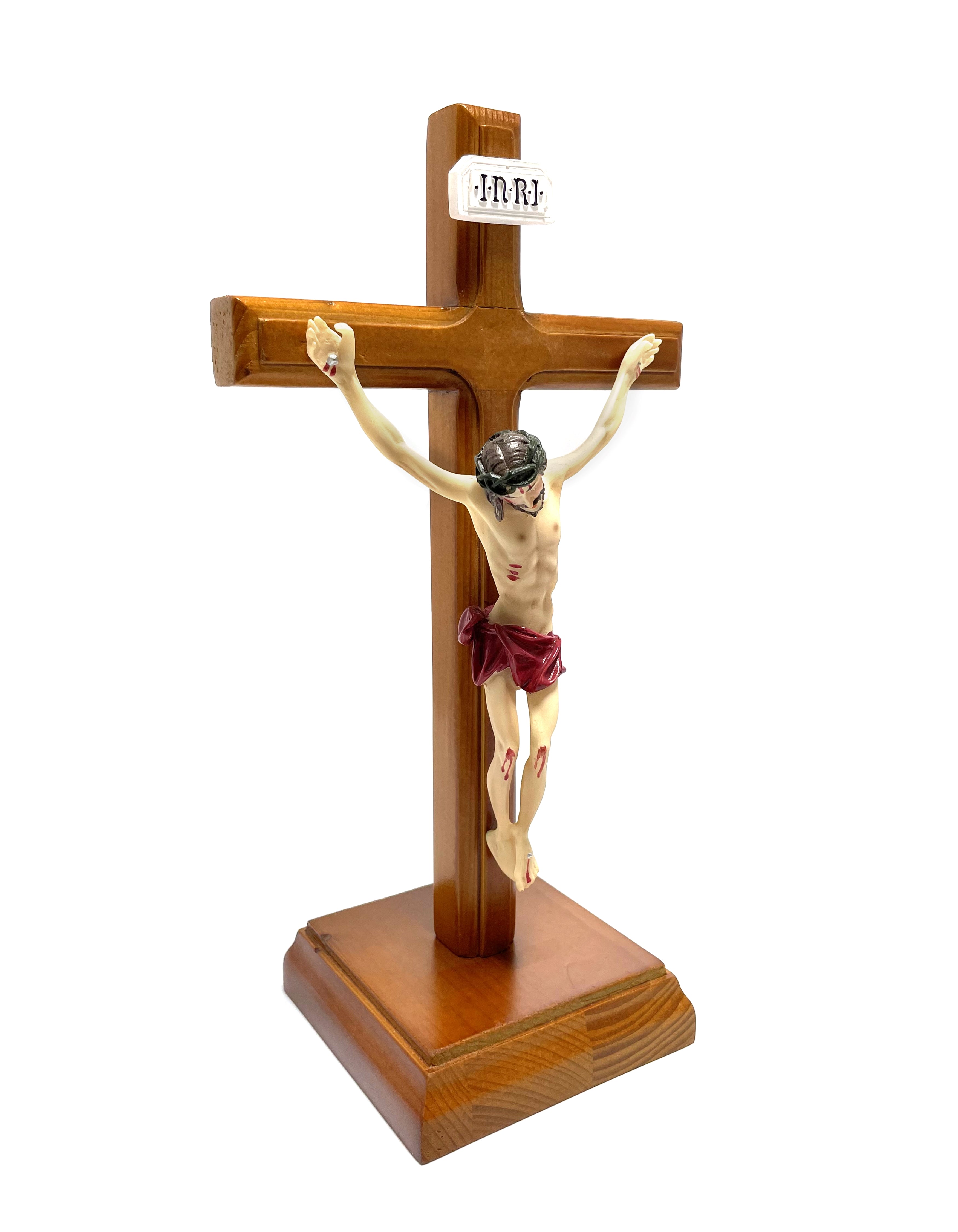 Crucifijo de madera con base cuadrada y cuerpo realizado en resina.